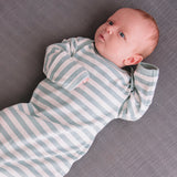 Baby in organic cotton and merino mix sleeping gown in a pale teal and white stripe